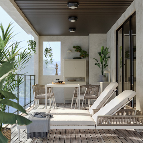 Balcón moderno con muebles de exterior blancos, barandilla de vidrio, plantas y vista.