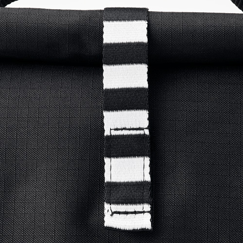 Bolso de rayas negras con asas resistentes que muestran su calidad, textura y diseño.