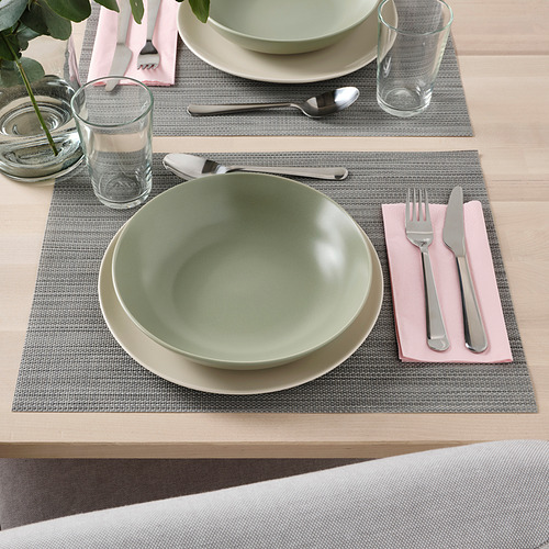 Montaje de la mesa con vajilla FÄRGKLAR: cuencos hondos, platos, cubiertos, vasos sobre manteles individuales.