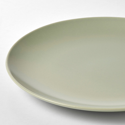Plato elegante, liso y con acabado verde mate, que forma parte del juego de vajilla FÄRGKLAR, que descansa sobre una superficie blanca y limpia.