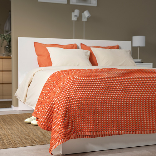 Cama con colcha PELARTUJA naranja, 4 almohadas, cabecero blanco, lámpara, zapatillas.