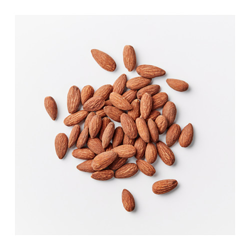 Almendras esparcidas sobre un fondo blanco liso. Una opción de refrigerio saludable para obtener energía.