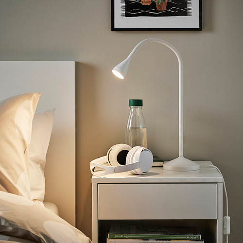 Moderna lámpara NÄVLINGE en mesita de noche con luz ajustable, auriculares, botella, libros.