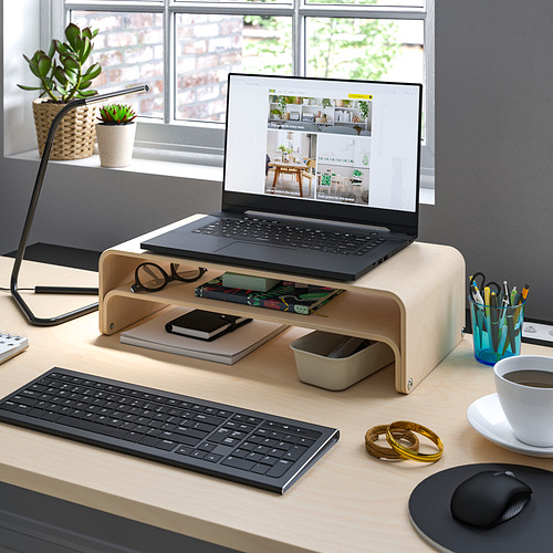 Espacio de trabajo organizado con soporte de madera para portátil VATTENKAR, teclado, ratón, café, accesorios de escritorio y plantas.