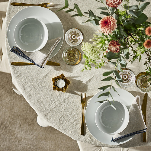 Elegante mesa con porcelana blanca IKEA 365+, cubiertos, vasos, servilletas y centro de mesa floral dorados.