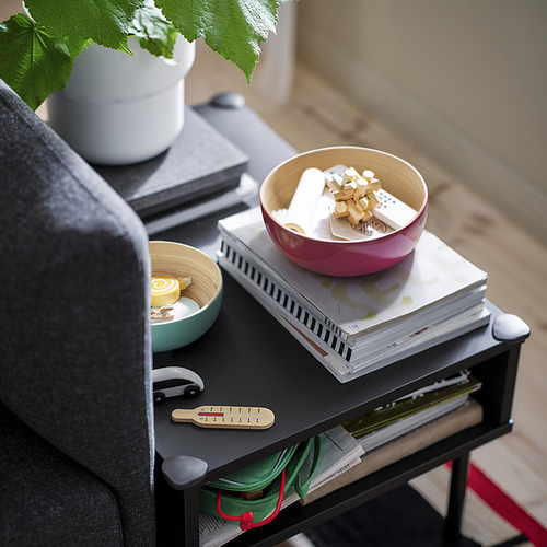 Cuencos de bambú sobre mesa con plantas y libros.