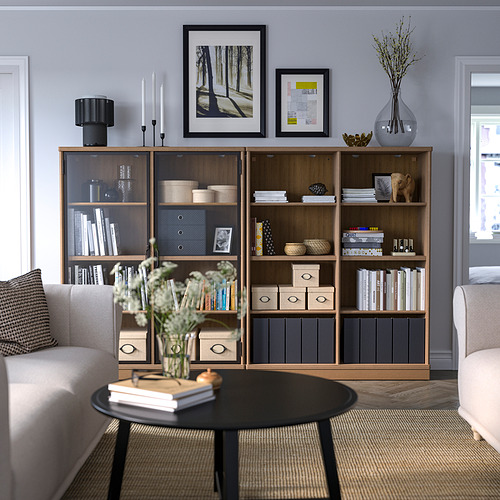 Sala de estar moderna con librería de madera, sillones, mesa de centro.