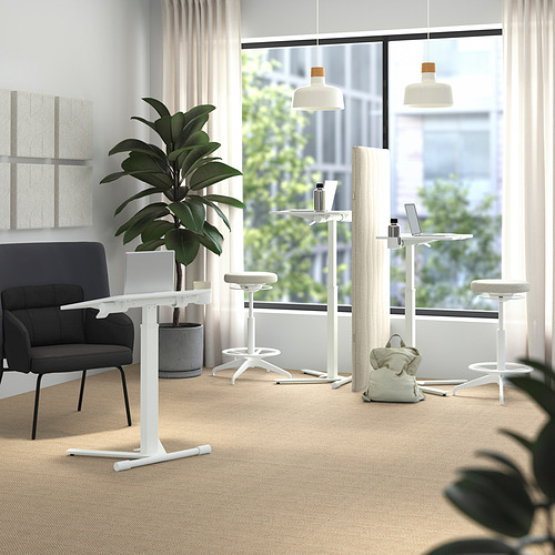 Moderna oficina con mesas ajustables MITTZON, taburetes blancos, planta verde y vista a la ciudad.