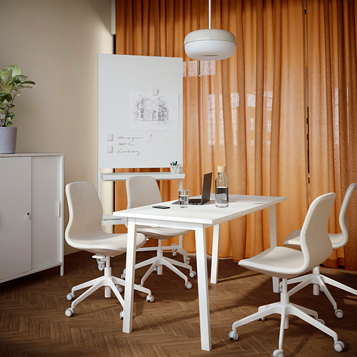 Mesa de oficina MITTZON, blanca con sillas beige, pizarra blanca, cortinas naranjas, suelo de madera, portátil, agua, planta pequeña.