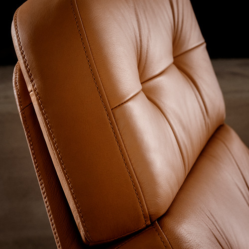 Sillón de cuero marrón en primer plano, con textura suave y costuras precisas.