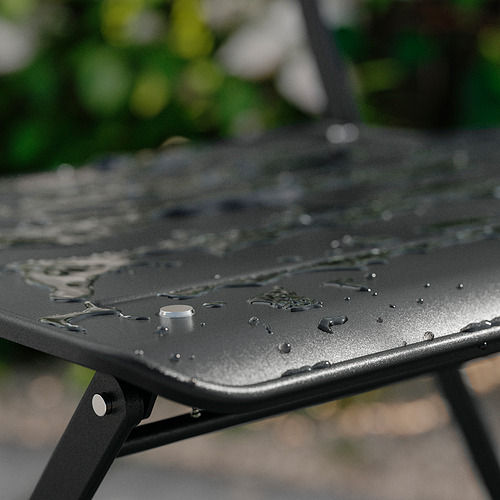 Mesa de exterior de metal negro con gotas de agua.