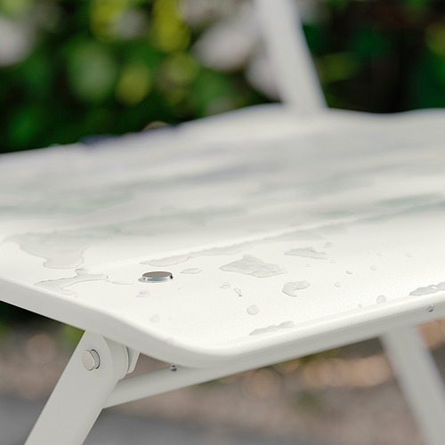 Superficie de mesa de metal blanco con gotas de agua, entorno exterior.