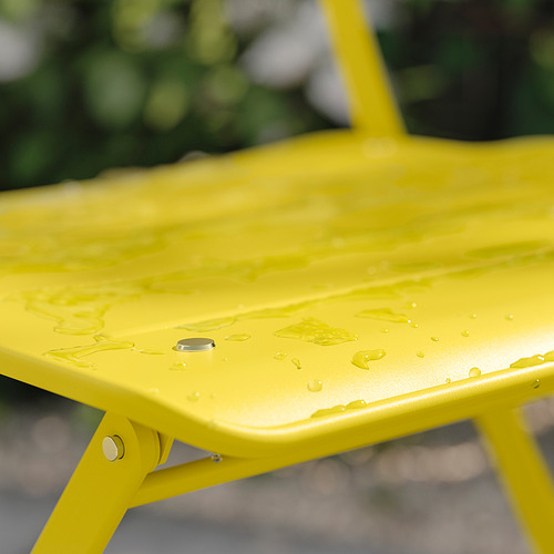 Mesa de exterior SUNDSÖ de color amarillo brillante con gotas de agua, fabricada en acero con recubrimiento en polvo, de diseño rectangular y moderno.