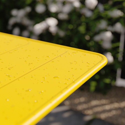 Mesa de exterior plegable de color amarillo brillante con manchas de agua, vista parcial, exterior.