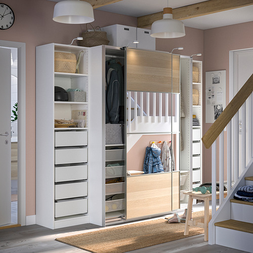 Un moderno armario PAX blanco y de madera clara con puertas correderas y compartimentos organizados.