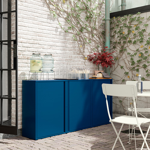 Mueble SUNDSÖ azul contra pared de ladrillo, tarros de cristal y silla blanca.