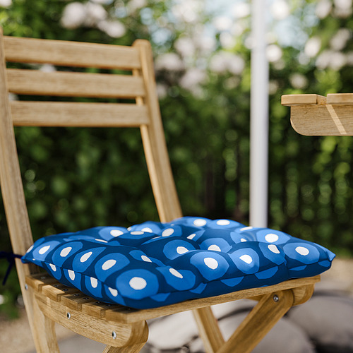 Silla con cojín de lunares azules y blancos en el exterior.