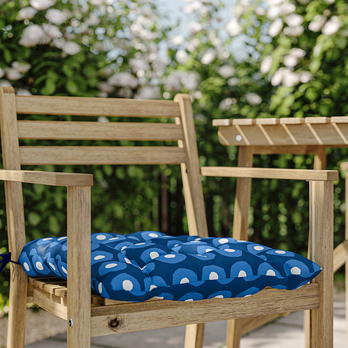 Banco de parque de madera con cojín redondo estampado en azul y blanco.