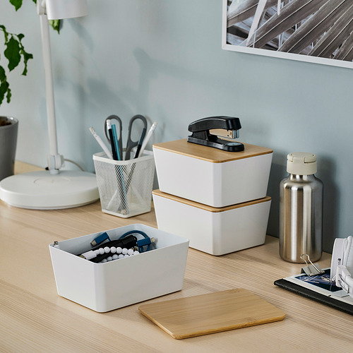 Caja blanca KUGGIS con tapa de bambú que contiene material de oficina sobre un escritorio. Organizador compacto inspirado en la naturaleza.