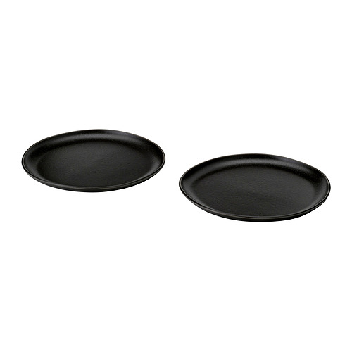 Dos platos redondos negros con un acabado texturizado y moteado se colocan uno al lado del otro.