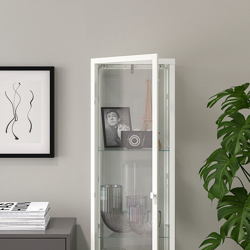 Mueble con puerta de cristal y estantes de cristal, jarrones y un cuadro enmarcado.