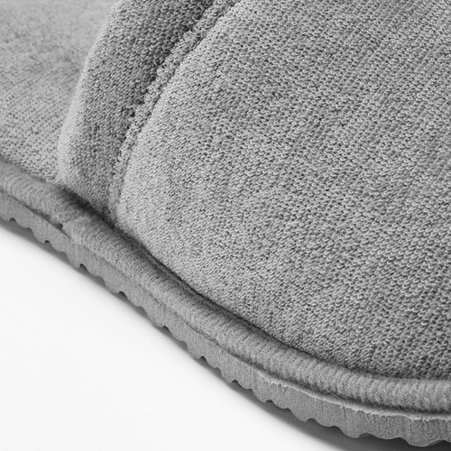 Zapatilla gris con tejido de punto texturizado y suela festoneada, con detalle de agarre.