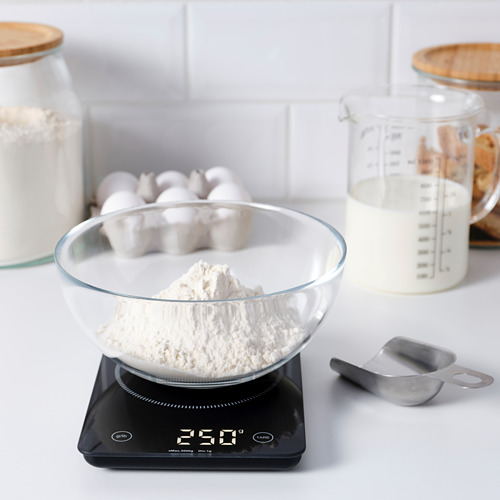 Recipiente de vidrio con harina en báscula de cocina digital, midiendo los ingredientes con precisión.