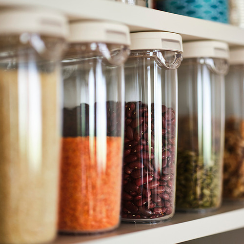 Estante con frascos transparentes que almacenan frijoles, arroz y hierbas; parte de la serie IKEA 365+ para el almacenamiento de alimentos.