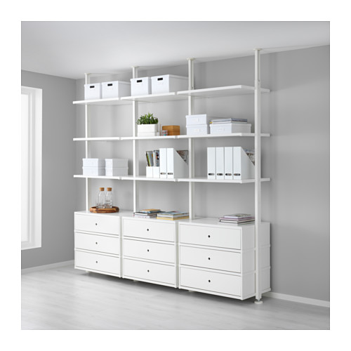 Almacenamiento de pared blanca ELVARLI: múltiples estantes, cajones y cubos abiertos. Alto, cabe libros, cajas, plantas. Configuración ordenada y organizada de la oficina en casa.