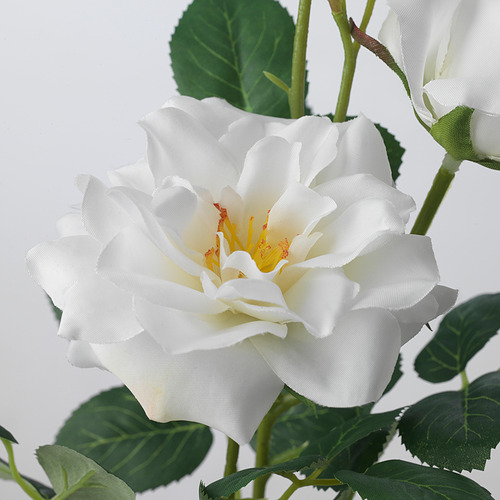 Preciosa rosa blanca artificial con hojas verdes, elaborada con materiales reciclados, realista y duradera.