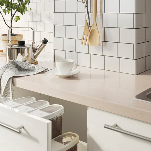 Encimera de cocina moderna con taza de té, prensa francesa y servilletas a cuadros. Tarros y utensilios blancos de IKEA. Diseño limpio.