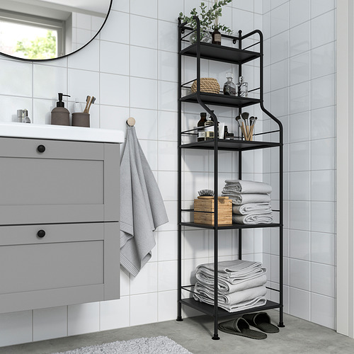 Estante FRÖSJÖN negro en el baño con toallas y artículos de tocador, junto al armario y el espejo.
