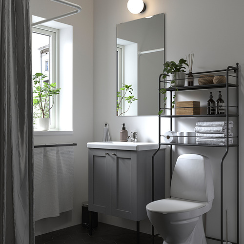 Baño moderno con decoración en blanco y gris. Sobre el inodoro, los estantes de alambre negro sostienen toallas y plantas. Inodoro blanco debajo.
