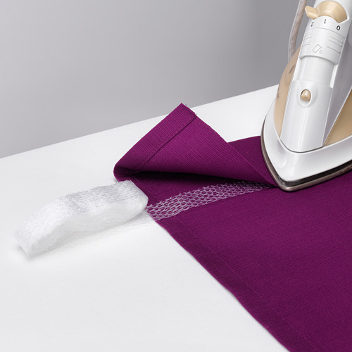 Una plancha blanca presiona una tela púrpura con tiras para dobladillos, lo que facilita el dobladillo sin coser.
