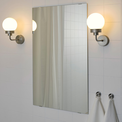 Espejo de baño con apliques y toallas.