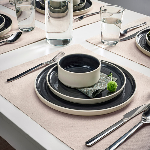 Mantel individual SVARTSENAP con platos, cuenco, cubiertos, vaso, servilleta y planta.