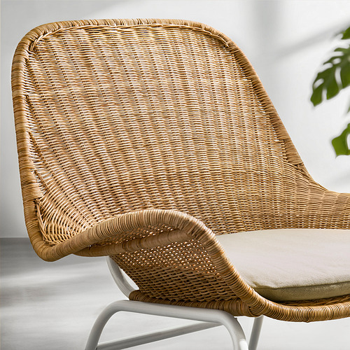 Un sillón de mimbre FRYKSÅS beige con cojín; Está diseñado para la comodidad y agrega una sensación natural.