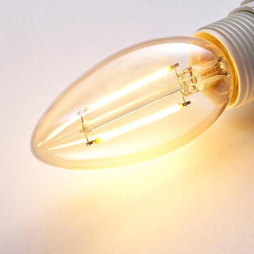 Primer plano de una bombilla LED de brillo cálido y eficiencia energética, que muestra su intrincado diseño de vidrio y filamento iluminado.