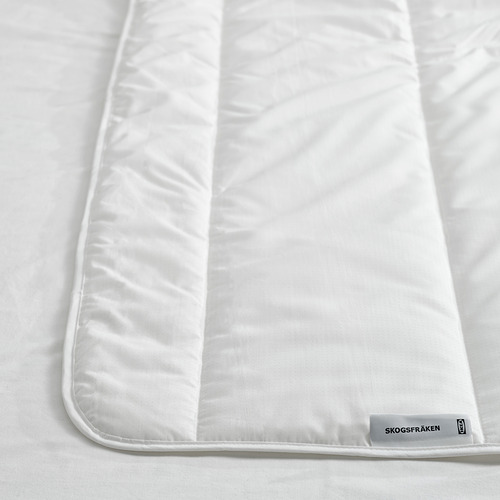 Edredón blanco fresco en la cama, cuidadosamente doblado; Textura suave y esponjosa, materiales reciclados.