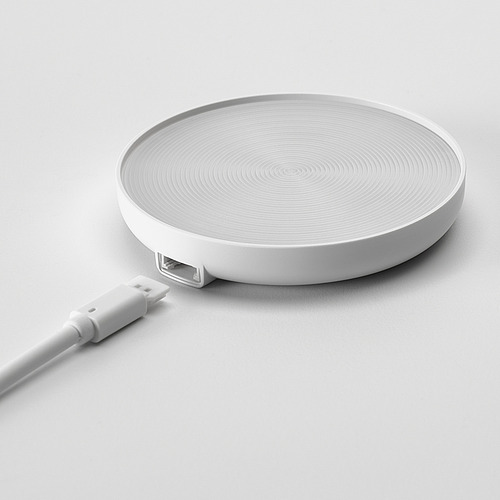 Almohadilla de carga plana y blanca con patrones giratorios. Cable USB conectado, listo para carga inalámbrica.