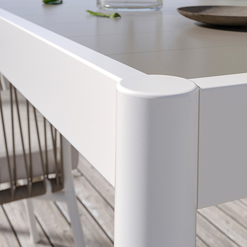 White modern outdoor table with circular support; sleek, minimalist design.