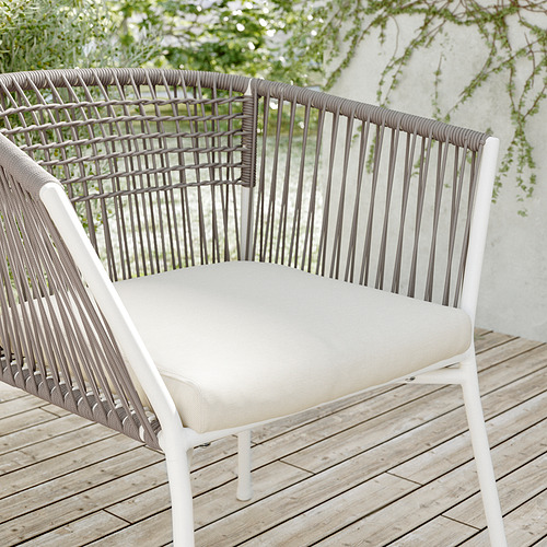 Silla de patio blanca moderna con respaldo tejido, cojín beige.
