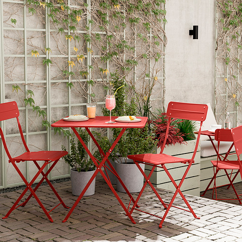 Conjunto de patio de metal rojo brillante con mesa y sillas, perfecto para espacios pequeños.