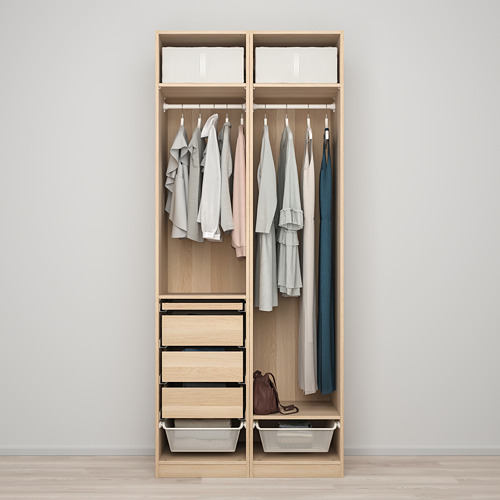 A minimalist closet holding shirts and tops, with four drawers and two wire baskets at the bottom for additional storage.