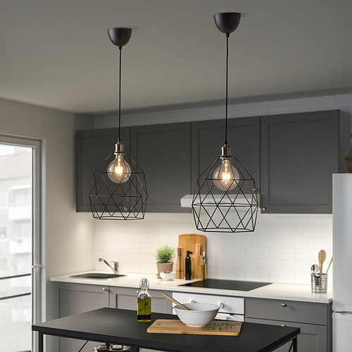 Cocina moderna con 2 lámparas BRUNSTA negras sobre isla, gabinetes gris oscuro, fregadero y mostrador blancos.