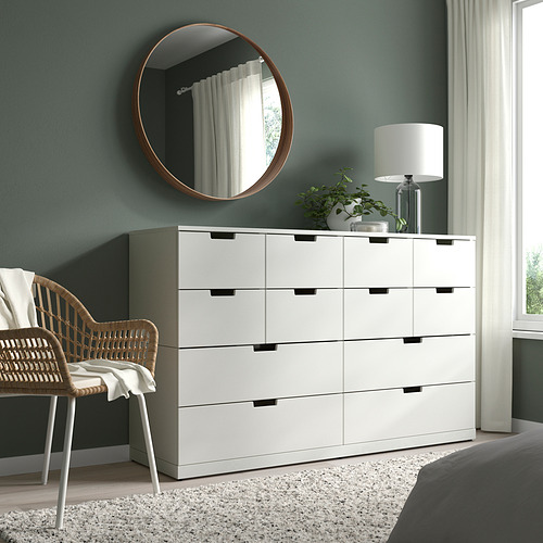Dormitorio moderno con tocador blanco STOCKHOLM, espejo, silla de mimbre, lámpara y planta.