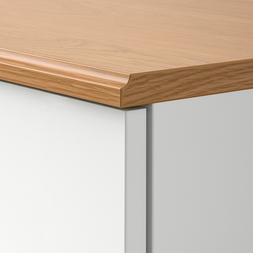 Primer plano del borde de la mesa SKRUVBY: elegante, tablero de madera clara, acabado liso, construcción sólida.