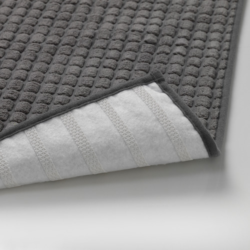 Alfombra de baño texturizada de color gris oscuro con respaldo antideslizante, que muestra durabilidad y seguridad.