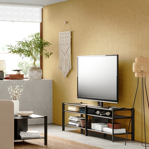 Sala de estar moderna con mueble de TV JÄTTESTA, paredes beige, plantas y decoración.