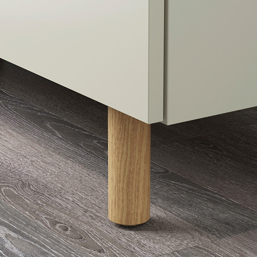 Pata cilíndrica de madera para armario, madera clara pulida, unida a un armario moderno con bordes lisos.